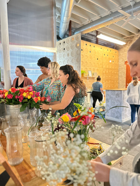 Making fresh flower arrangements at a summer self care retreat.
